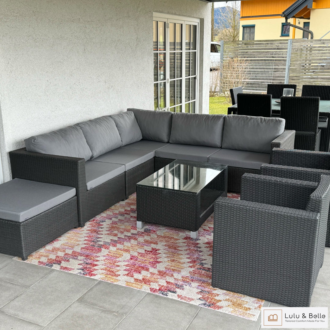 Rattan-Ecklounge auf einer überdachten Terrasse mit neuen grauen Sitzauflagen und Rückenpolstern nach Maß