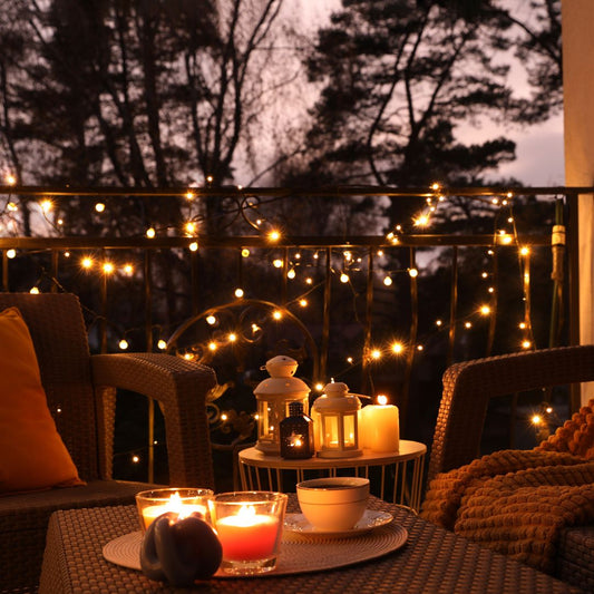 Terrasse im warmen Abendlicht mit Auflagen, Decke und Laterne